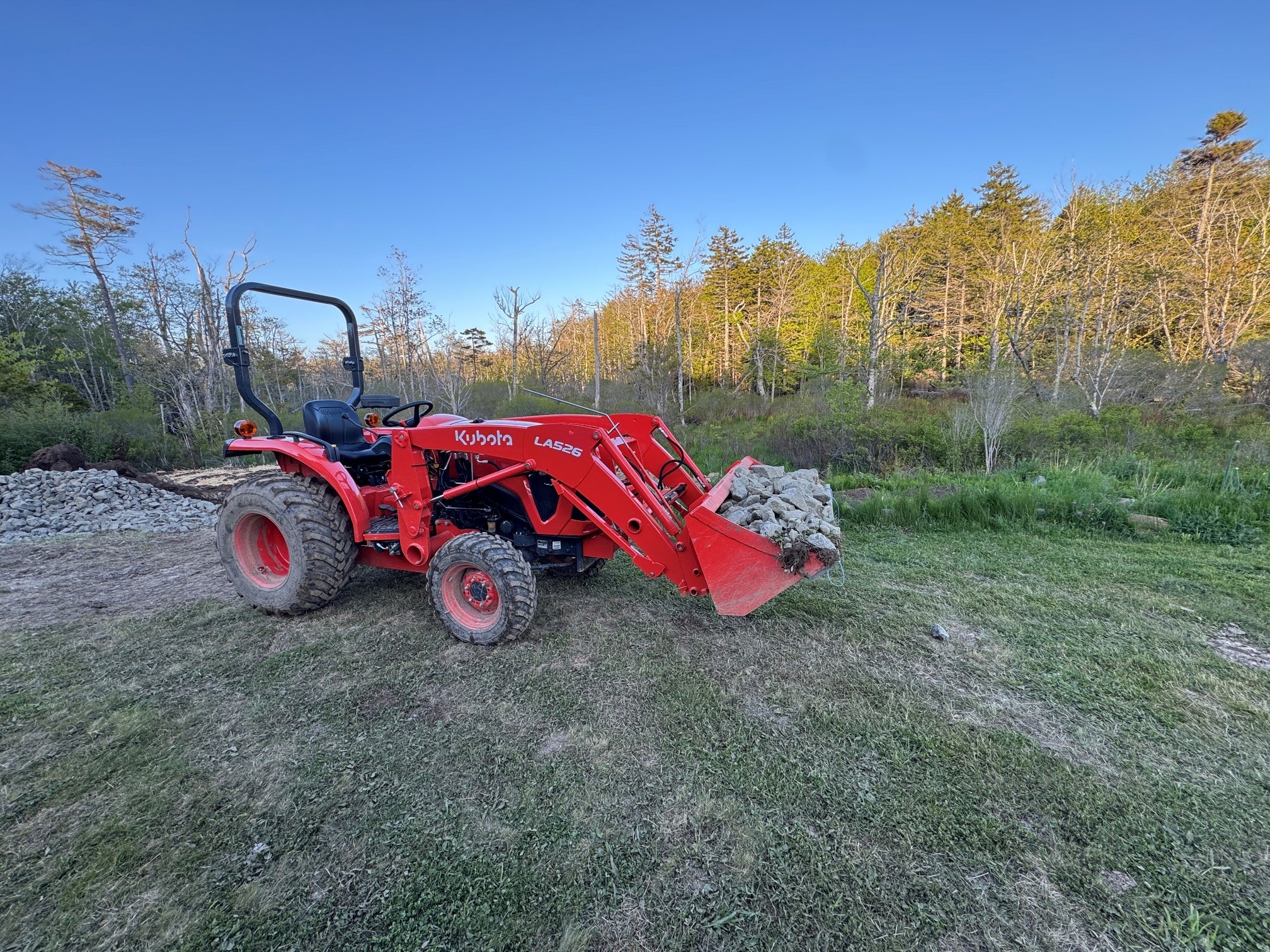 Kubota L2502 with LA526 front-end loader moving rocks