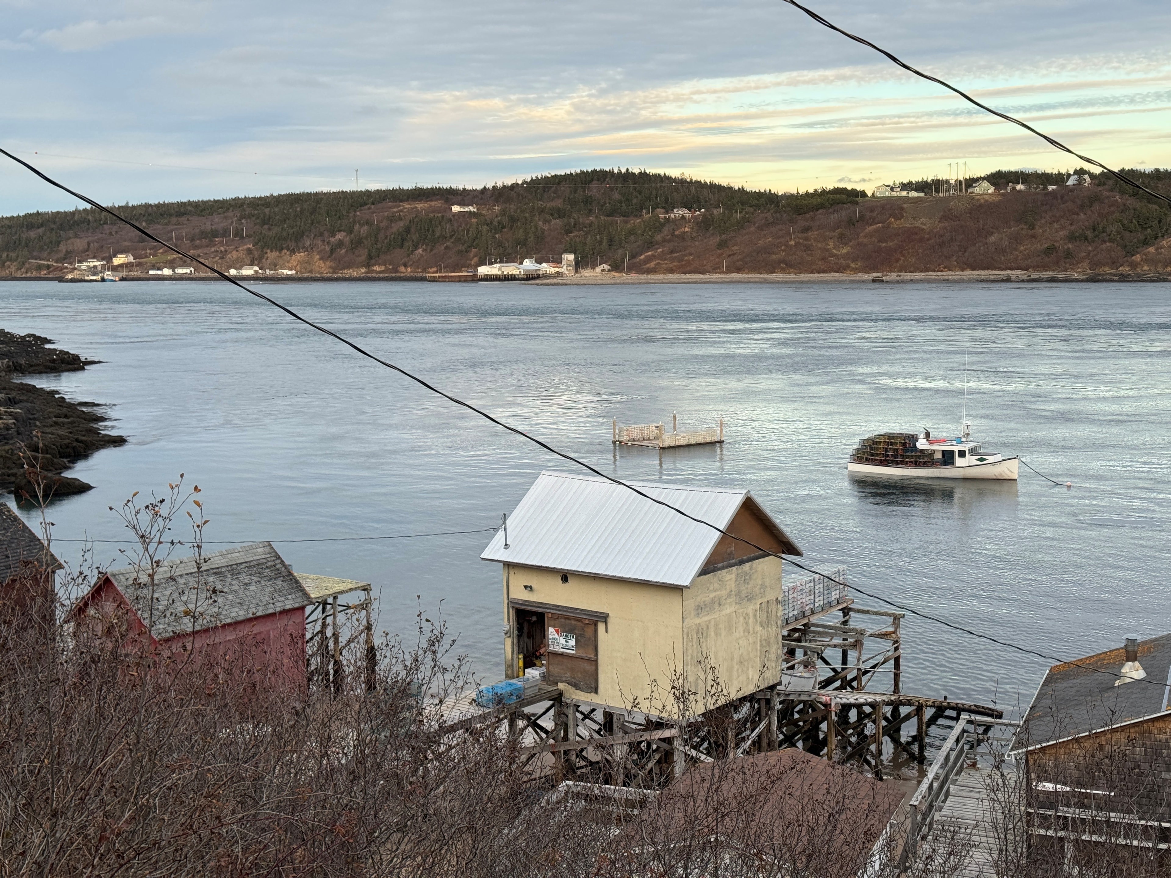 Coastal Nova Scotia waterfront with fishing boat on calm water